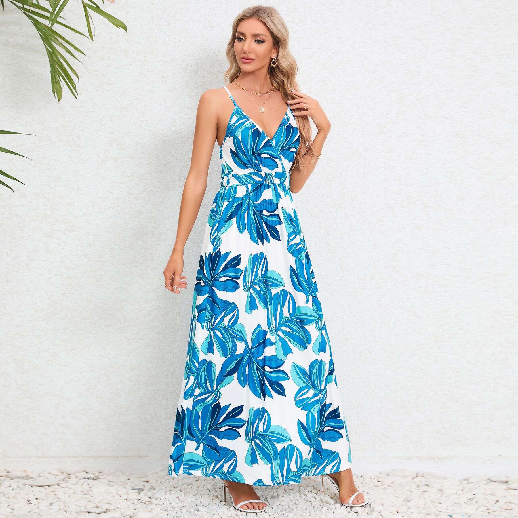 Fashionable blue and white tropical print maxi dress perfect for summer, beach, or vacation wear. Features spaghetti straps, V-neckline, and comfortable flowy design.