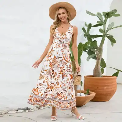 Stylish floral maxi dress perfect for summer, featuring a vibrant orange and white pattern, sleeveless design, and flowy silhouette for casual outdoor events.