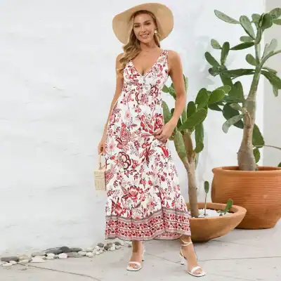 High-resolution image of a smiling woman wearing a stylish floral maxi dress, accessorized with a sun hat, jewelry, and carrying a woven bag. Perfect fashion for summer, vacation, or casual outings.