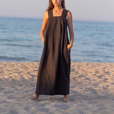 Stylish long linen dress for women on the beach with ocean backdrop.