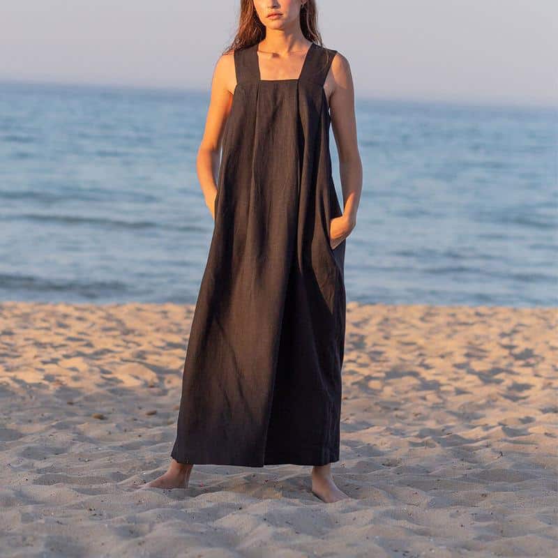 Stylish long linen dress for women on the beach with ocean backdrop.