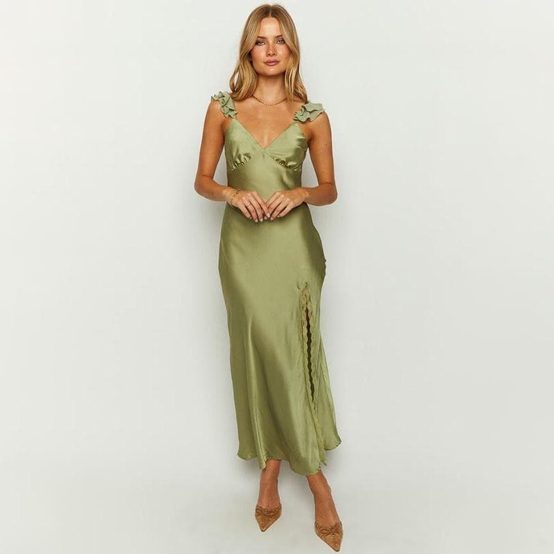 Woman in satin green dress with ruffle shoulder details, V-neckline, and high slit, perfect for formal occasions or stylish events.
