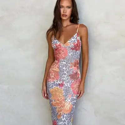 High-resolution image of a model wearing a colorful floral dress with leopard print accents, perfect for fashionable summer or spring wear. The dress features thin straps and a fitted silhouette.
