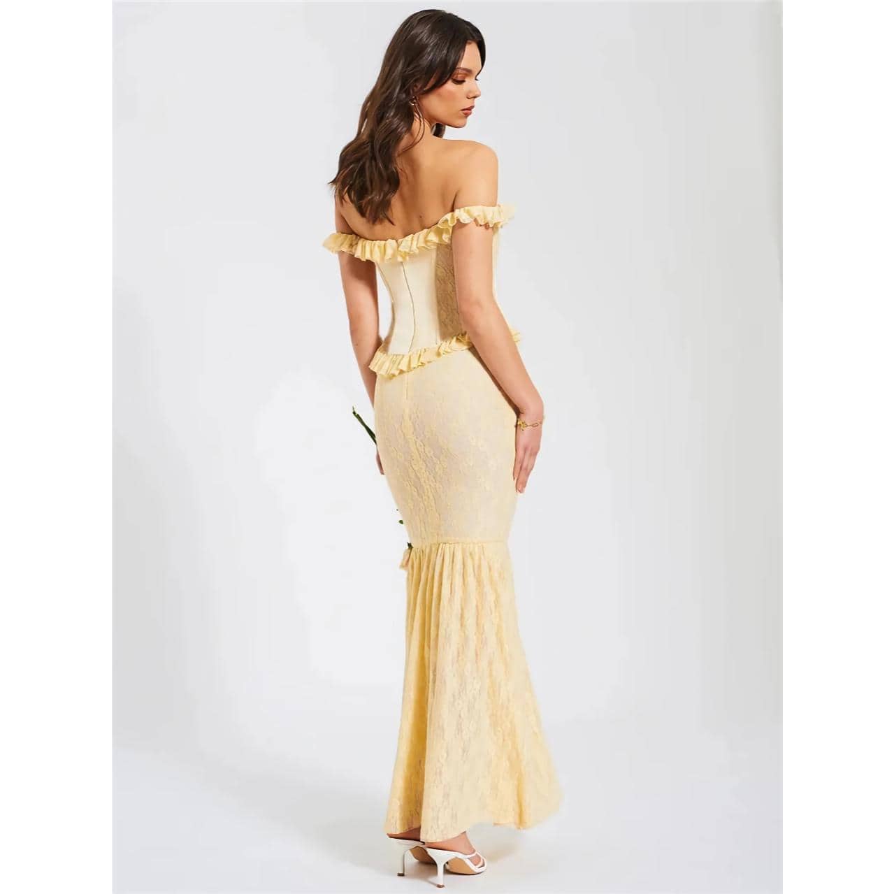 A beautiful woman wearing a yellow lace off-shoulder gown with ruffle accents, perfect for evening events or formal occasions, showcasing sophisticated fashion.