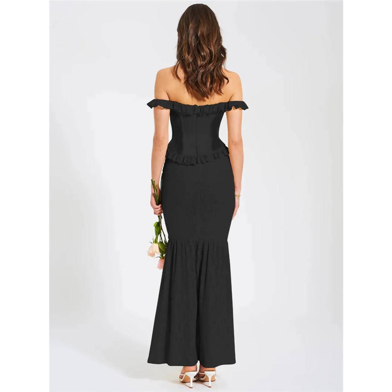 Stylish black off-shoulder evening gown with ruffle details, perfect for formal occasions, weddings, or special events. Flattering silhouette with a sleek finish, designed for confident women.