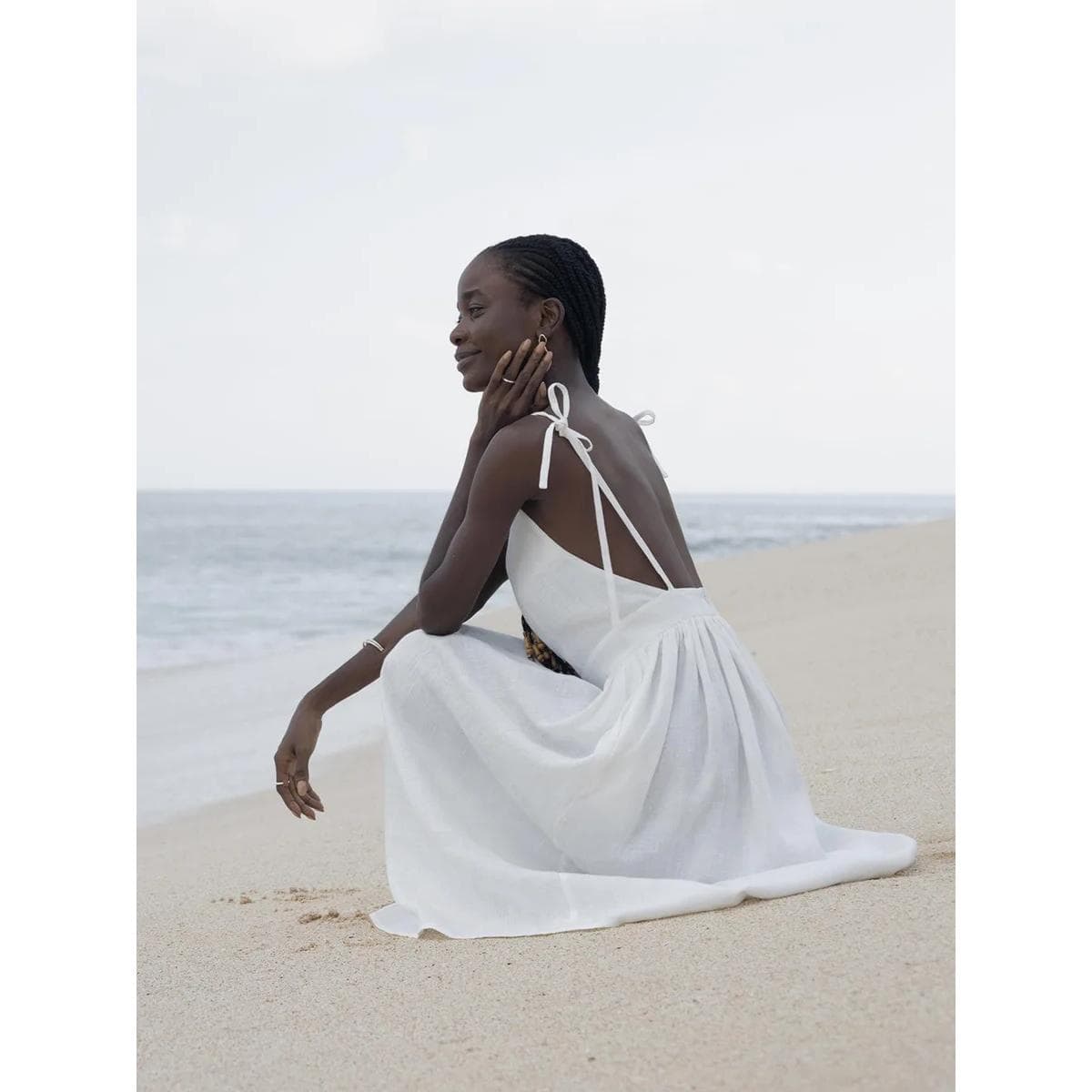 Beautiful woman in white dress on the beach, showcasing stylish swimwear and beach fashion options available at Monalisa Store. Perfect for summer and beach outings.