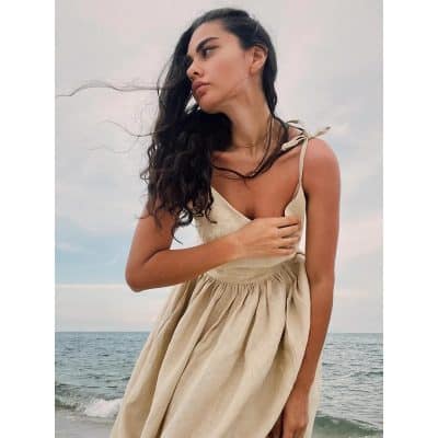 Stunning woman wearing stylish glasses outside by the sea, showcasing trendy optical frames perfect for fashion-conscious individuals, with a focus on premium optics and eyewear at Monalisa Store.