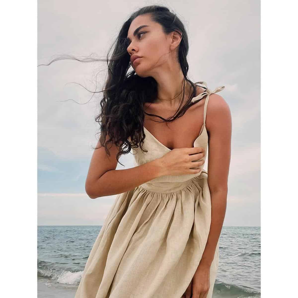 Stunning woman wearing stylish glasses outside by the sea, showcasing trendy optical frames perfect for fashion-conscious individuals, with a focus on premium optics and eyewear at Monalisa Store.