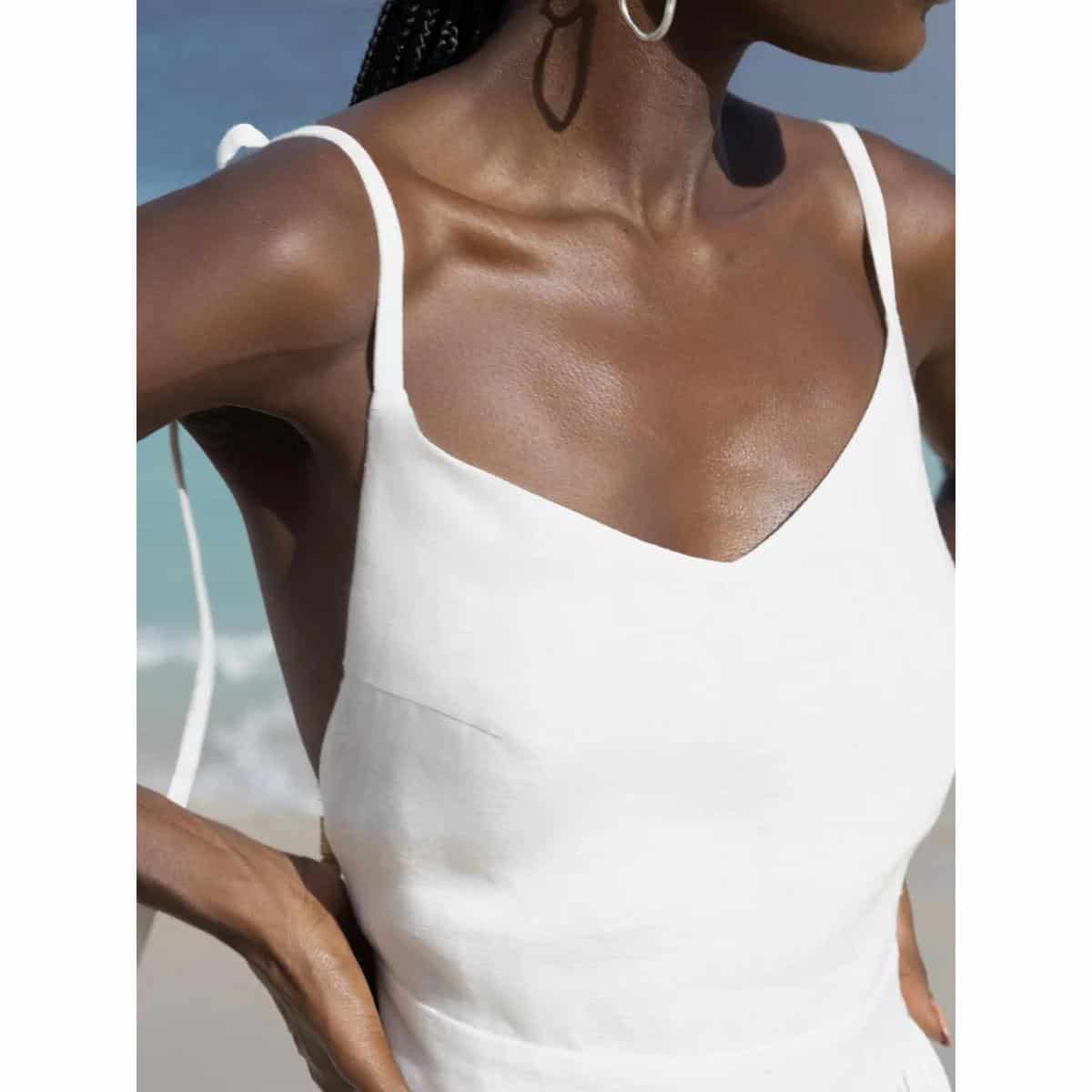 Beautiful woman's shoulder and face from the side at the beach. Emphasis on smooth, glowing skin perfect for skincare, beauty, and cosmetic treatments at Monalisa Store.