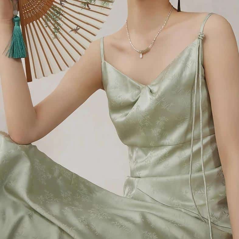Women's satin dress with delicate floral pattern, adjustable spaghetti straps, and sophisticated design, ideal for formal occasions and Asian-inspired fashion.