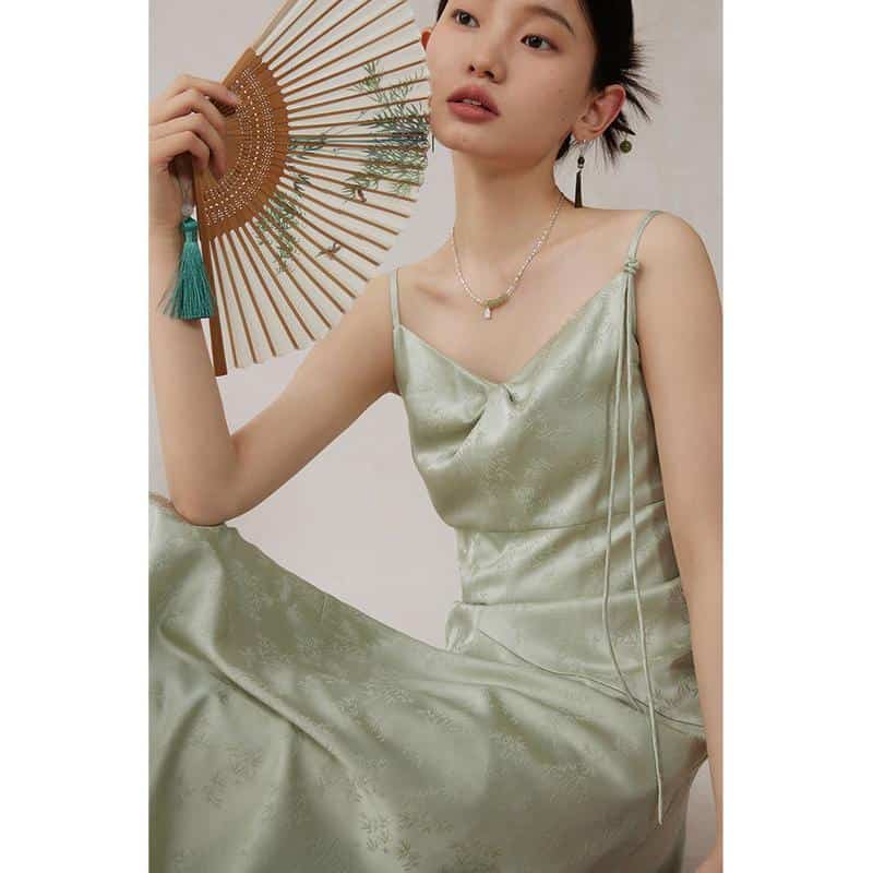 Image of a woman in a luxurious silver satin dress holding a traditional hand fan, showcasing stylish and comfortable women's fashion from Monalisa Medical Store.