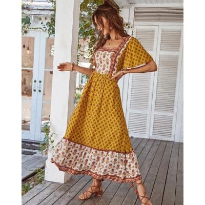 A woman wearing a yellow boho floral maxi dress with intricate embroidery and ruffle hem, perfect for summer outings and casual occasions.