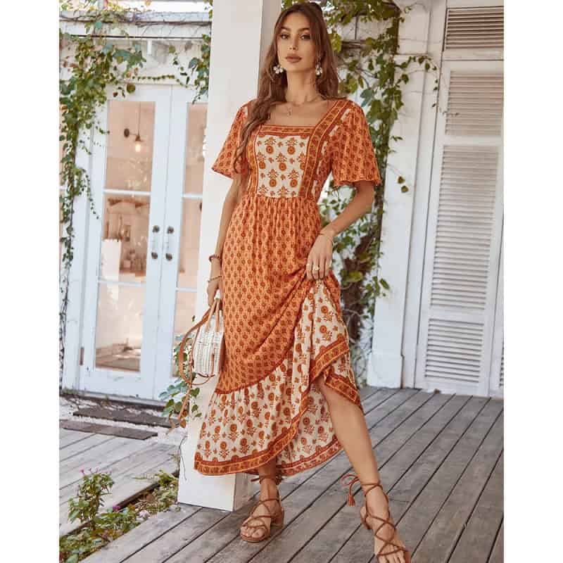 Stylish bohemian maxi dress with intricate orange and cream embroidery, perfect for summer and casual outings. Made with lightweight, breathable fabric, offering a comfortable fit and chic look.
