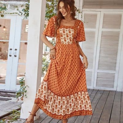 Elegant orange and white bohemian style maxi dress with floral patterns, perfect for summer or casual outings. Features comfortable fit and intricate embroidery details.
