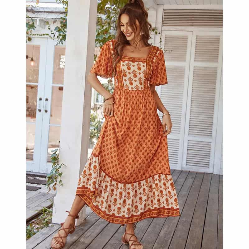Elegant women's boho maxi dress in orange with floral patterns.